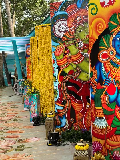Vibrant, large-scale mural panels depicting Lord Krishna, used as a stunning walkway decoration for a culturally themed wedding event.