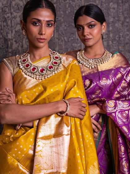 Our models showcase two distinct bridal looks: a vibrant yellow Kanchipuram with polka dots and a royal purple brocade, both perfect for different wedding functions.