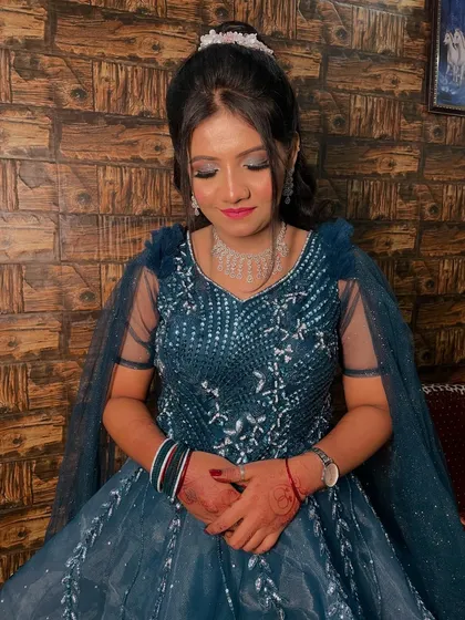 A princess moment for her engagement. This bride-to-be looks stunning in a teal blue gown with silver smokey eyes and an elegant updo.
