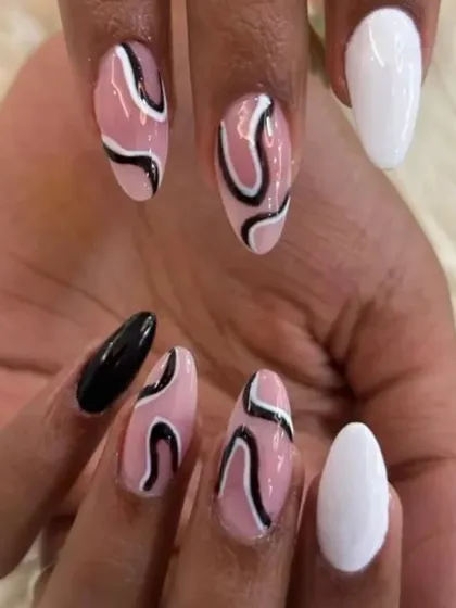 Another perspective of the abstract swirl manicure, showing the full hand and the interplay between the solid and patterned nails.