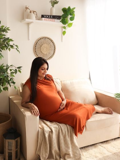 A solo portrait capturing the mom-to-be relaxing in our lifestyle setup. The natural light from the window and the comfortable setting make for a beautiful, authentic image.