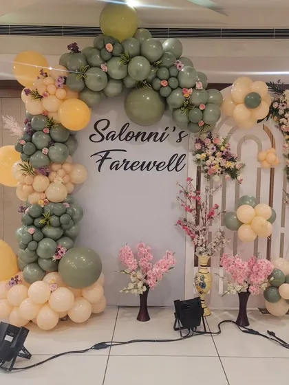 For this farewell party, I created a stylish photo booth using a custom backdrop and an organic balloon arch in trendy sage green and peach tones. This setup combines fresh flowers with modern balloon artistry for a memorable celebration.