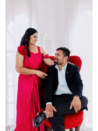 A sweet moment between the couple during their studio pre-wedding session. The red and white color scheme is striking and romantic.