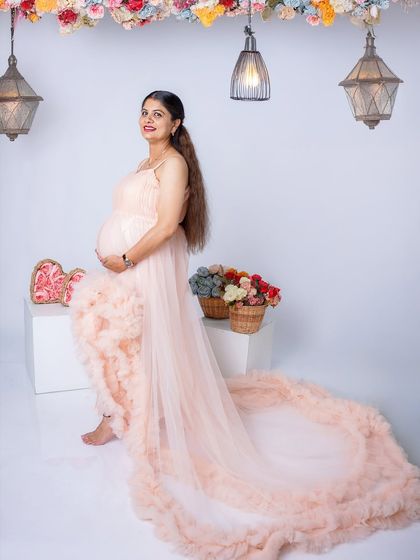 A dreamy solo portrait featuring a delicate peach-colored ruffled gown. The soft textures and colors create a very feminine and gentle image.