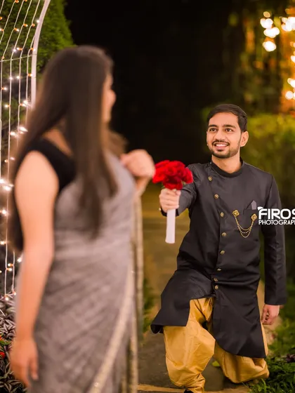 A playful and romantic proposal shot, with the fairy light archway creating a magical and memorable setting.