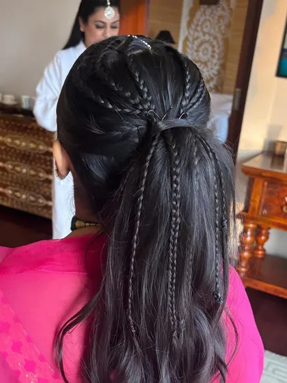 A detailed back view of the ponytail with multiple thin braids. It's a fun and intricate style that's perfect for festive occasions.
