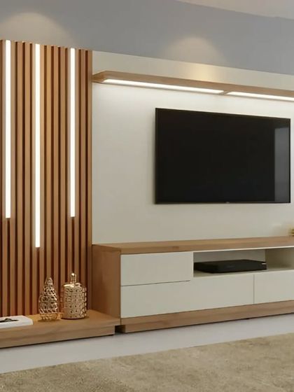 A clean and contemporary TV wall featuring vertical wood slats with inset LED lighting. The floating console provides storage without taking up floor space, enhancing the room's modern feel.