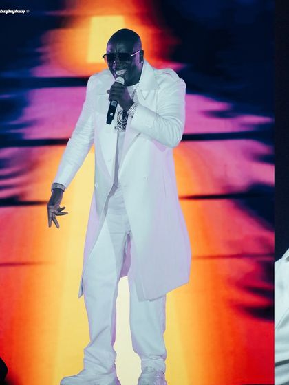 A collage of Akon's performance, showing him in his signature all-white suit against a colorful, dynamic stage background.