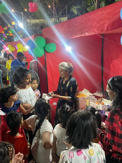 A crowd of excited kids gathering around the DIY station, eager to get their hands on some donuts and sprinkles.
