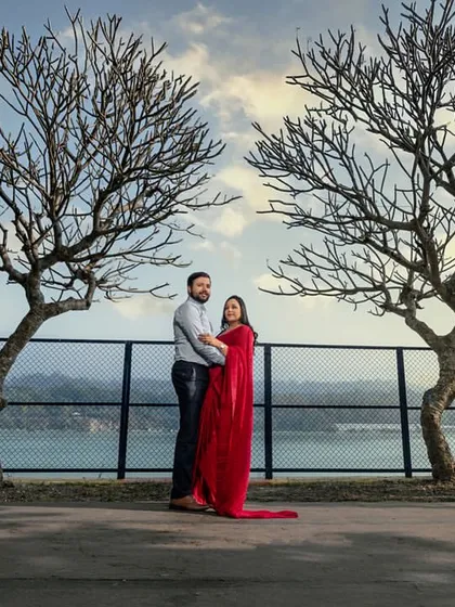 Framed by two bare trees against the water and hills, this shot has a beautiful, symmetrical composition that highlights the couple standing together as one.
