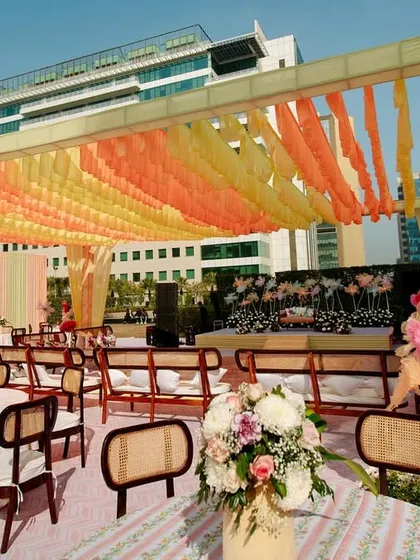 The guest seating area for the urban Haldi, with a canopy of orange and yellow ruffled drapes that add a bright and festive touch.