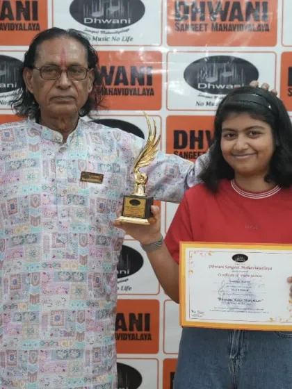 A senior guru with a student and her award.