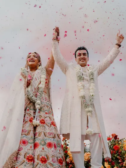 The pure, unscripted joy of a couple celebrating their union under a shower of petals. This is the kind of vibrant, emotional moment I live to capture, where happiness is the most beautiful detail.