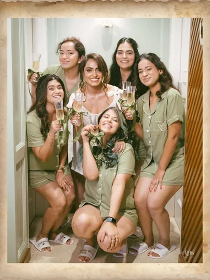 The bride and her bridesmaids in matching pajamas, sharing a laugh and a toast. A perfect capture of the fun and relaxed moments before the ceremony.
