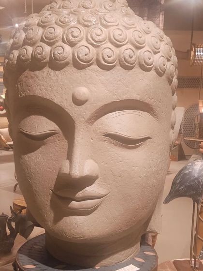 A close-up of the large, serene Buddha head sculpture, highlighting its texture and calming presence.