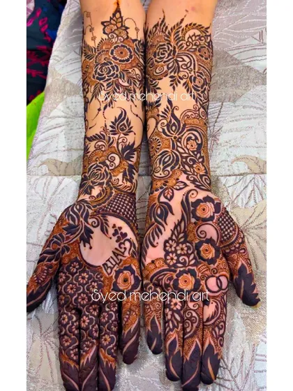 An intricate engagement henna design where I incorporated the groom's name, "Bilal," into the floral patterns on the palm. I specialize in weaving personal elements like names and dates seamlessly into the artwork.