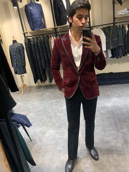 A mirror selfie showing our maroon velvet blazer with contrasting grey lapel details. The rich color is perfect for autumn or winter weddings.