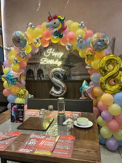 A closer view of the unicorn balloon arch over the birthday table, showing the mix of pastel colors and shiny foil balloons.