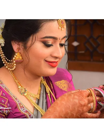 A candid moment from an engagement ceremony. This look is all about soft elegance, with classic gold eyeshadow, a bright red-orange lip, and a natural finish that looks beautiful from every angle.