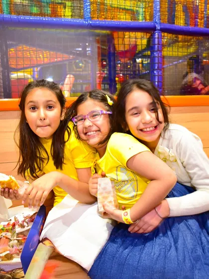 Three friends sharing a laugh and a snack after an exciting play session.