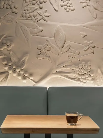 To tell the story of coffee, we collaborated with a local artist on this textured mural for Café Coffee Day. This custom art piece depicts the journey from the coffee plantations of Chikkamagaluru to the cup, grounding the modern space with a nod to the brand's heritage.