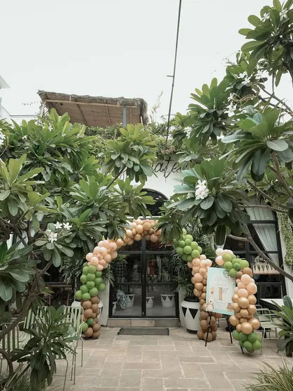 The entrance to the cafe, marked by a beautiful organic balloon arch in the party's theme colors.