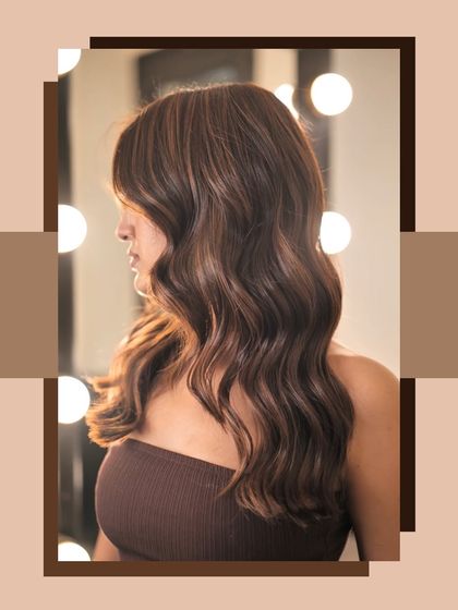 A side profile of the caramel gold highlights, showing how the light catches the different tones in the hair. The vanity lights in the background add a touch of salon glam.