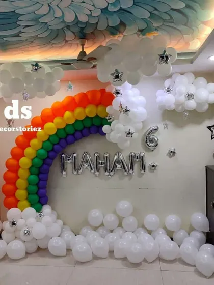 A slightly different angle of the large rainbow and clouds balloon installation, showing how it creates a stunning feature wall in a living room.