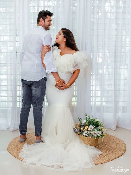 A sweet couple's pose on a simple jute rug, with a basket of flowers adding a pop of color. This shows how we can create beautiful moments with minimal props.
