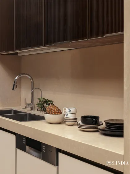 Even the sink area can be beautifully styled. Here, stacked ceramics, a bowl of fruit, and a small plant add color and texture to the countertop, turning an everyday utility space into a curated moment.