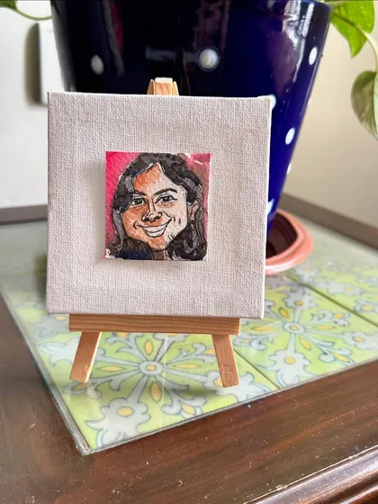 My mini portrait of Archana displayed on an easel.