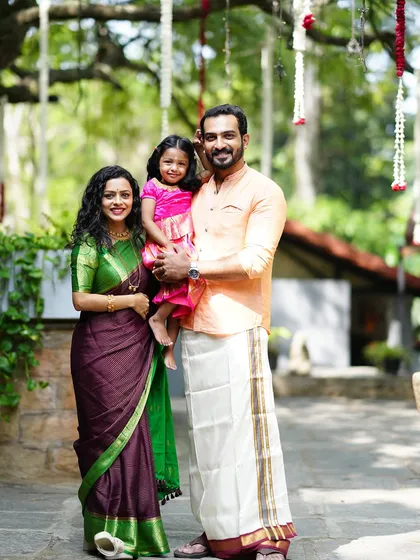 A beautiful, traditional family portrait taken outdoors. The family is dressed in elegant ethnic wear, creating a timeless and classic image.