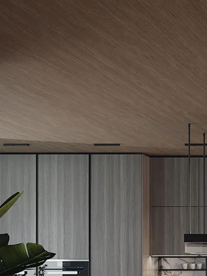 This design seamlessly blends style and functionality. The use of different wood textures on the ceiling and cabinets, combined with a marble backsplash, redefines elegance in the heart of the home.