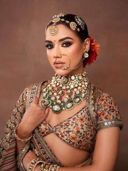 A powerful and regal bridal portrait. The look features intense kohl-rimmed eyes, a strong contour, and traditional jewelry for a timeless appeal.