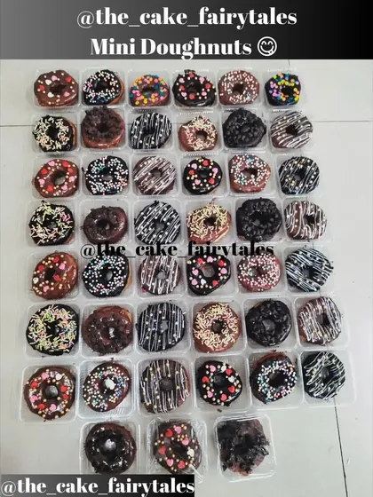 A big batch of my freshly baked mini donuts, all ready for a party. You can see the variety of toppings I offer, from chocolate drizzles and heart sprinkles to colorful strands and choco chips.