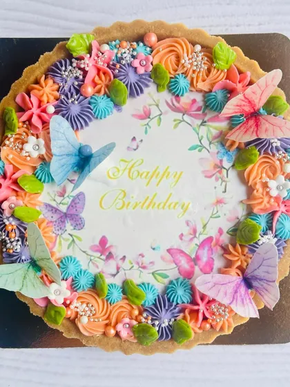 This birthday tart is a beautiful example of my floral and butterfly theme, with a custom 'Happy Birthday' message surrounded by a wreath of colorful buttercream flowers.