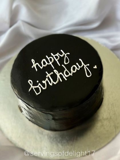 A minimalist black chocolate glazed cake with simple "happy birthday" script. This sleek and modern design makes a bold statement.