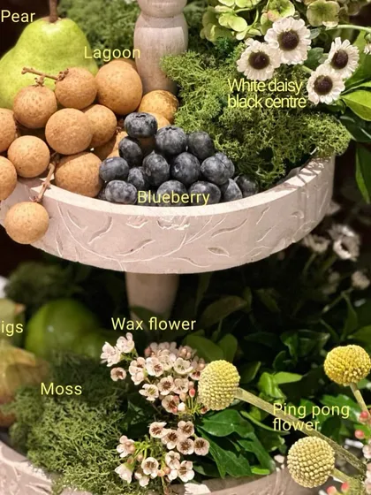 The magic is in the details. In my masterclass, we break down every single element. You'll learn how to compose a centerpiece like this one, understanding the role of each component, from the figs and blueberries to the specific textures of moss and wax flowers.