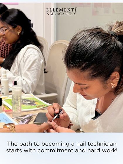 The path to becoming a professional nail technician starts with commitment and hard work. Here, a student is deeply focused on perfecting her application technique during a class.