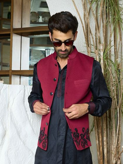 A closer look at the tailored maroon waistcoat over a black kurta. This ensemble is the definition of timeless elegance, redefined for the modern gentleman.