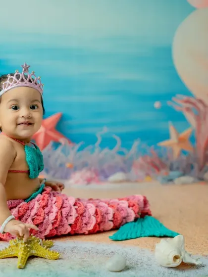 A happy smile while playing with a starfish prop. I provide a variety of sea-themed props for babies to interact with, which helps in capturing their natural curiosity and playful expressions.