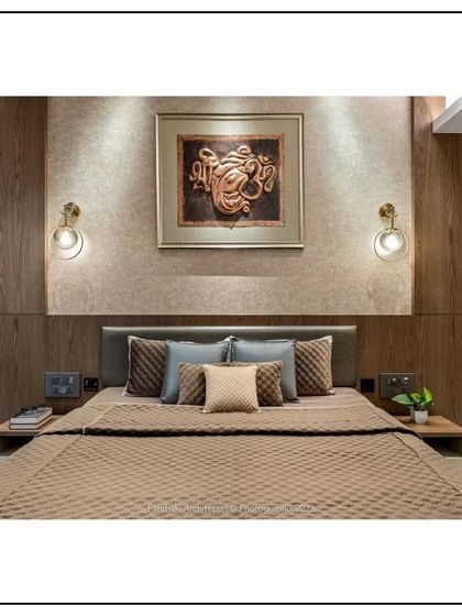 Symmetry and balance define this calming bedroom design. Matching bedside tables and wall sconces frame the bed, while textured wallpaper and a prominent art piece add layers of visual interest.