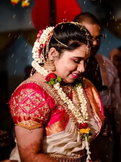 The Akshatai ceremony is a beautiful part of the wedding. Her makeup is set perfectly to remain flawless throughout the rituals, with a classic South Indian bridal hairstyle adorned with fresh jasmine and roses.