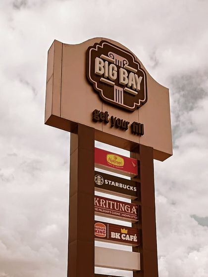 A close-up of our main pylon sign, listing some of our top brands against a dramatic sky.