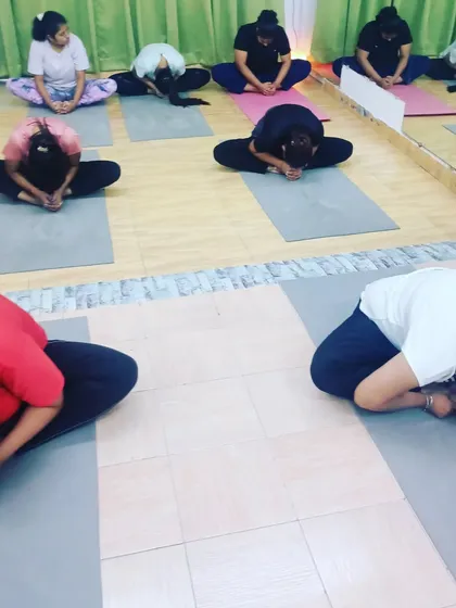 Students in Baddha Konasana (Bound Angle Pose) with a forward bend. This pose is excellent for opening the hips and releasing tension in the inner thighs.