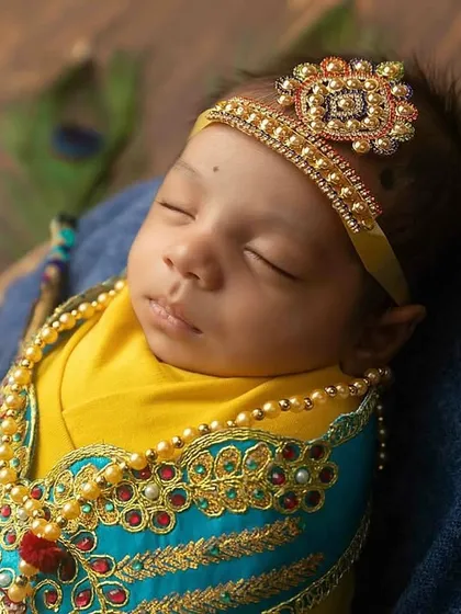 A detailed close-up from the Little Krishna newborn shoot, focusing on the beautiful costume and serene expression.