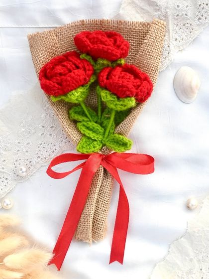 A classic and rustic bouquet of three red crochet roses, wrapped in burlap and tied with a simple red ribbon.