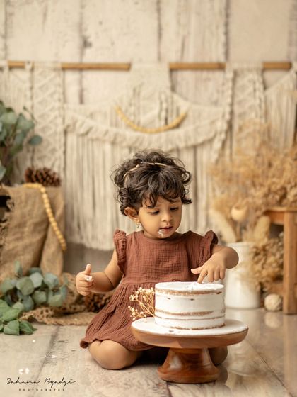 A rustic, boho cake smash with a simple, elegant cake. This little girl's expression is so sweet.