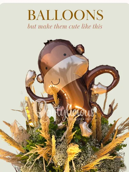 Balloons, but make them cute like this. A cheeky monkey foil balloon peeking out from a bouquet of dried grasses is a fun and rustic-chic arrangement.
