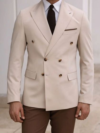 A mannequin showcasing a cream double-breasted blazer paired with brown trousers. We offer a wide variety of color options to create your perfect look.